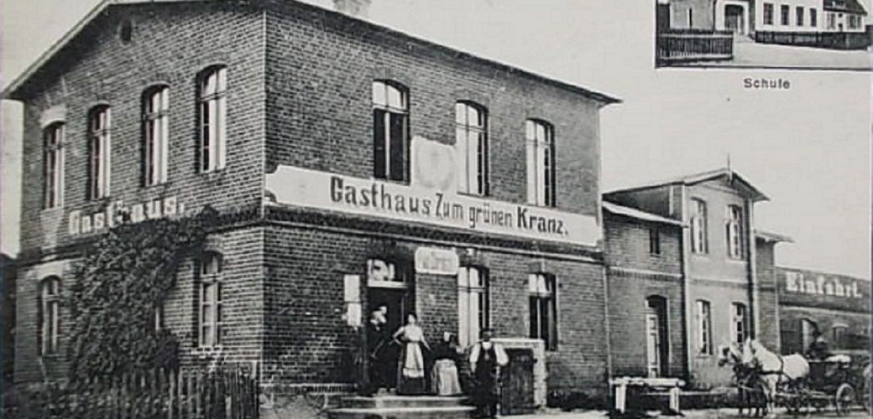 Foto: Fotopolska.eu.: Zdjęcie zajazdu i karczmy oraz szkoły w Brudzawach z 1915 roku. Napis 'Gasthaus Zum grünen Kranz'  można przetłumaczyć, jako 'Zajazd Pod Zielonym Wieńcem'. Zapewne przed budynkiem stoi ówczesny karczmarz August Goroncy z rodziną lub pracownikami.