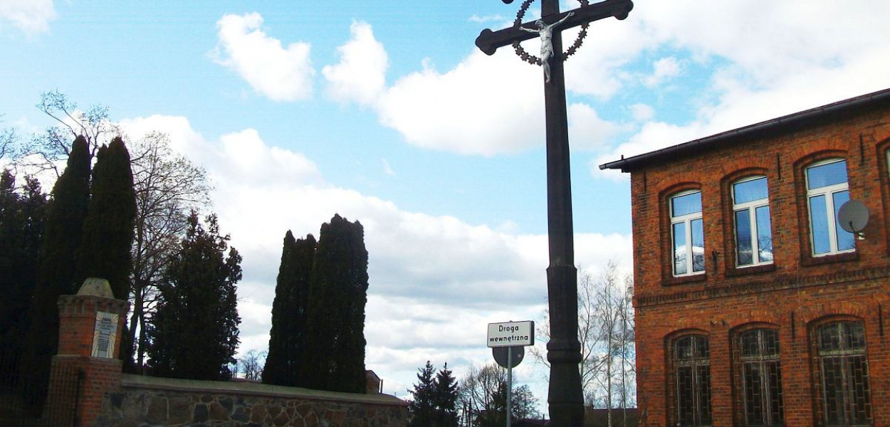 Foto: Maria Oryszczak: W Jastrzębiu (gmina Bartniczka) wyjątkowy krzyż o dwu poprzeczkach stoi w centrum wsi, przy dwustuletnim kościele i upamiętnia mieszkańców zmarłych na zarazę.